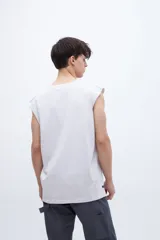 Musculosa verde oliva con cuello redondo y estampado pequeño en el pecho. Corte recto y sin mangas.