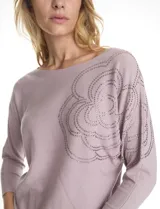 Buzo de tejido de punto fino marca LIV Milano, color violeta, con diseño de manga japonesa y largo tres cuartos. Presenta un aplique de brillos en la parte frontal y lateral que forma un diseño floral.