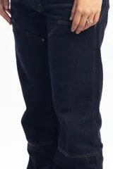 Pantalón de jean azul oscuro de corte recto, con refuerzos en las rodillas y bolsillos laterales. Diseño de estilo cargo con frente reforzado.