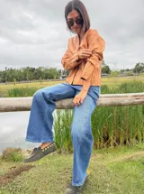 Chaqueta corta de cuero ovino color camel, con cuello redondo, cierre frontal con botones a presión y bolsillos laterales. Diseño holgado y flexible.