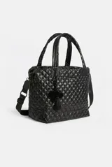 Cartera tote maxi bag color negro, con diseño acolchado y pespuntes en rombos. Cuenta con doble asa de mano, correa ajustable y extraíble, cierre superior y detalle de llavero con pompón y borla colgante.