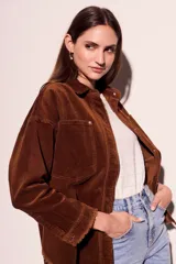 Sobrecamisa de pana color rojo, con cierre frontal de botones, bolsillos delanteros con solapa y ruedo desflecado.