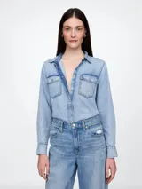 Camisa de jean de calce clásico con lavado acid wash, cuello camisero, cierre frontal con botones metálicos y dos bolsillos frontales con solapa.