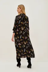 Vestido midi de corte recto con escote en V, mangas largas y estampado floral sobre fondo negro.