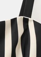 Vestido midi de corte evasé con diseño de rayas verticales en blanco y negro, escote palabra de honor y detalle de cinturón fino en la cintura.
