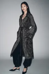Kimono largo de terciopelo con cuello solapa, manga larga y cinturón ajustable del mismo tejido. Presenta bordados con hilo metalizado, bolsillos laterales ocultos y acabados desflecados.