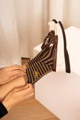 Medias de punto a rayas marrones y negras, con detalle de logo bordado en tono amarillo.