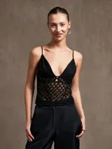 Top negro con breteles finos, escote en V y cuerpo de encaje con diseño geométrico.