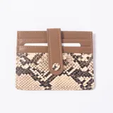 Tarjetero de cuero sintético con diseño combinado en tono marrón y estampado animal print de serpiente, con múltiples ranuras para tarjetas y tira con botón a presión.