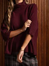 Poleron negro de tejido de punto con cuello alto doble y mangas 3/4 con puños acanalados.