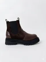 Botas tipo chelsea de cuero, combinando texturas en color bordó. Presentan paneles laterales elásticos en negro, suela track robusta y tiradores en la parte superior.