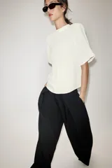 Pantalón de tiro alto con pernera ancha y pinzas delanteras. Cuenta con bolsillos laterales ocultos en la costura y cierre frontal con cremallera, botón interior y gancho.