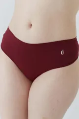 Bombacha tipo culotteless de microfibra sin costuras, con tiro bajo y cintura elástica. Presenta un diseño minimalista con un pequeño logo estampado en el frente.