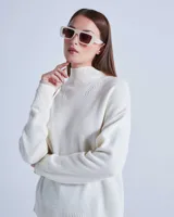 Sweater de lana color crema con cuello alto y mangas largas. Posee detalles calados en la parte superior del pecho y diseño acanalado en puños y ruedo.