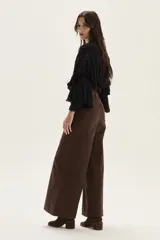 Cardigan de tejido de punto con detalles calados, trenzas y flecos en mangas y espalda. Presenta cierre frontal con botones, cuello redondo y mangas tres cuartos.