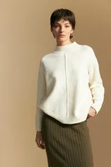 Polera de tejido de punto color blanco, con cuello alto acanalado, hombros caídos y detalle de costura vertical en el frente.
