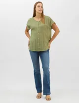 Blusa de corte fluido confeccionada en algodón con tejido texturizado de patrón a cuadros. Presenta mangas cortas caídas, escote redondo y cierre frontal con botones.