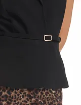 Vestido midi de estilo sastre con cuerpo tipo chaleco negro de cuello solapa y escote en V, con cierre lateral y cinturón con hebilla. La falda es plisada con estampado animal print y cuenta con forro interno.