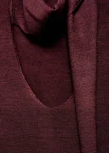 Jersey de punto fino color bordó, de diseño recto con escote en V y manga larga. Cuenta con un adorno de fular integrado en el cuello.