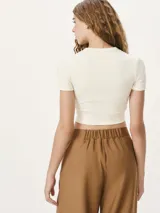 Blusa cropped de manga corta en tela acanalada, color naranja, con cuello redondo y diseño ajustado.