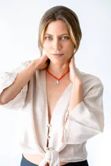 Collar corto de mostacillas color naranja con dije de rama plateada.