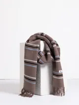 Bufanda de tejido suave en color marrón chocolate con diseño de rayas horizontales en tonos naranja, beige y gris. Presenta terminaciones con flecos en los extremos.