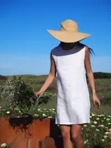 Vestido corto color blanco, sin mangas, con cuello redondo y diseño de corte recto y holgado.