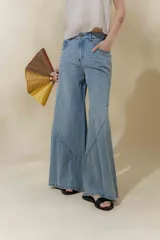 Jean de tiro medio color azul claro, con corte ajustado en la cintura y piernas anchas con cortes curvos en el ruedo. Incluye bolsillos delanteros y bolsillos plaque en la espalda.