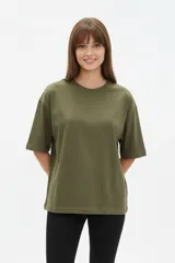 Remera de algodón verde militar, de corte ancho, mangas cortas y cuello redondo a la base.