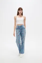 Pantalón jean de tiro alto y corte recto, color azul claro, con bordados de pequeños corazones rojos y rosados en toda la prenda.