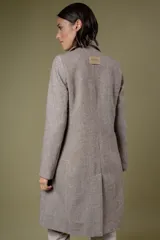 Tapado de corte sastre con diseño de espiga en tonos blanco y negro. Cuenta con solapas clásicas, cierre frontal de un botón y bolsillos laterales.