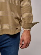 Sobrecamisa beige a cuadros negros y verdes, de manga larga y corte recto.