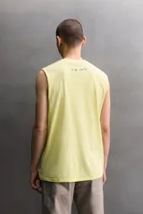 Musculosa relaxed fit de algodón color amarillo claro, con cuello redondo y pequeño estampado floral en el borde inferior.