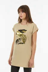 Remera de algodón blanca, de corte holgado, manga corta con vuelta y cuello redondo. Cuenta con un estampado frontal abstracto con trazos en tonos marrón y foil dorado.