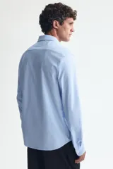 Camisa H&M de corte slim fit en mezcla de algodón con rayas finas celestes y blancas. Presenta cuello italiano, cierre frontal con botones y mangas largas.