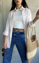 Camisa beige con rayas verticales blancas, de corte holgado y largo a la cadera.