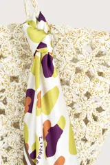 Pañuelo cuadrado de tejido ligero con estampado abstracto de manchas en tonos amarillo, morado y tierra sobre fondo blanco, con borde decorativo en tono marrón.