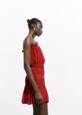 Vestido corto rojo de diseño asimétrico con un solo tirante ancho y fruncidos en el escote y el bajo. Cuenta con un panel fruncido en la cintura y un cinturón de cadena dorada desmontable.