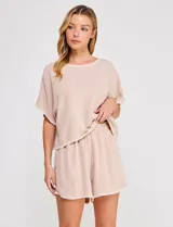 Short de tiro alto color beige, confeccionado en mezcla de lino y viscosa, con cintura elastizada y detalles bordados en el ruedo.