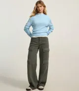 Blusa de punto color blanco con cuello alto y manga larga.