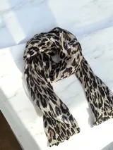 Pañuelo de textura plisada con estampado animal print en tonos beige, negro y marrón.