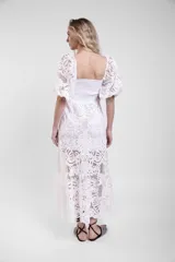 Vestido largo de encaje blanco con cuerpo fruncido elastizado, mangas cortas abullonadas y falda con vuelo.