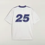 Camiseta Adidas Originals x Oasis de manga corta, color blanco con detalles en azul marino. Presenta cuello polo, las tres tiras características de la marca en los hombros, el logo del trifolio y un estampado frontal con la inscripción "oasis".