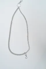 Cinturón de cadena metálica plateada con eslabones tipo grumete y cierre de mosquetón en ambos extremos.