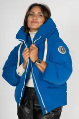 Campera puffer azul con capucha, cierre frontal con cremallera y bolsillos laterales.