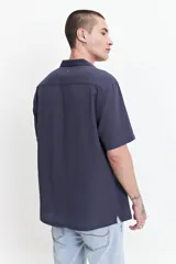 Camisa blanca de manga corta con textura, fit regular y logo bordado.