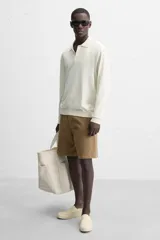 Zapatilla slip-on negra de tejido de algodón con elásticos laterales y suela color crema.