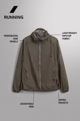 Chaqueta cortavientos de tejido técnico con estructura ripstop, cuello subido con capucha, cierre frontal de cremallera, bolsillos laterales ocultos y zonas perforadas para mayor transpirabilidad.