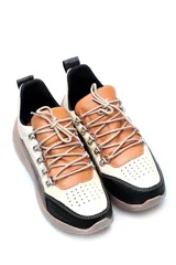 Championes deportivos acordonados de cuero, con diseño combinado en tonos beige, marrón y negro. Presenta suela de plataforma en color tostado y detalles metálicos en los ojales de los cordones.