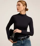 Blusa negra de manga larga, confeccionada en microfibra ligera de poliamida con elastano, con cuello alto.